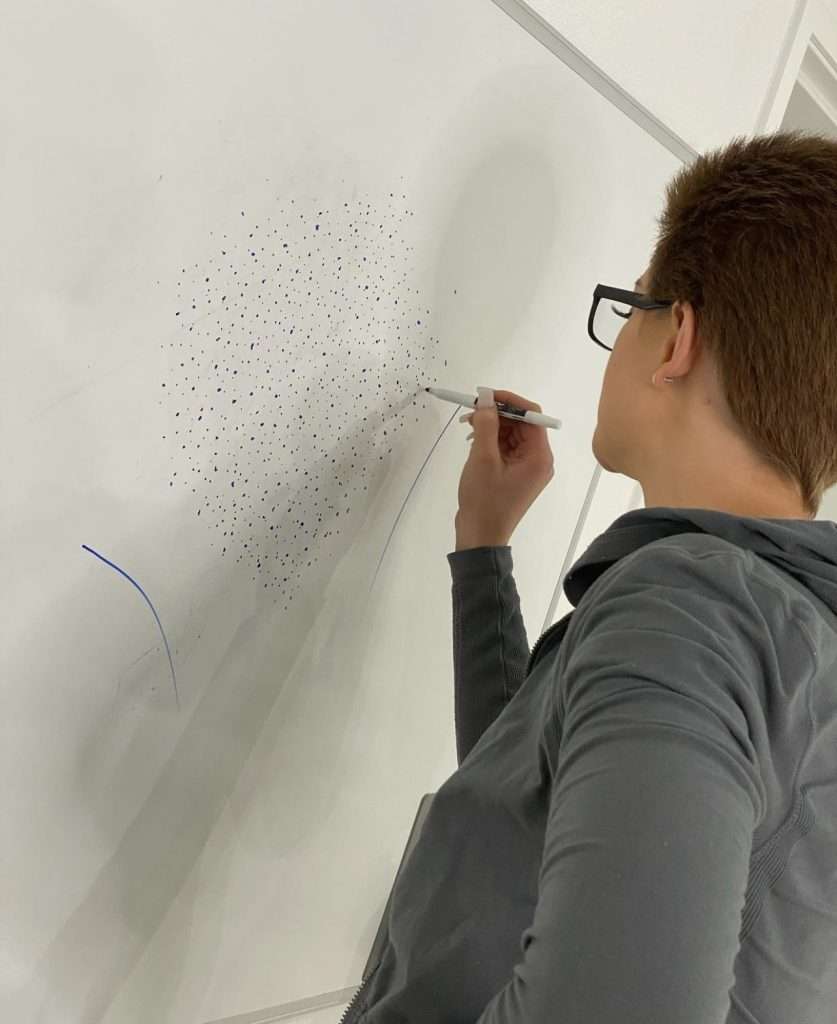 A girl sketching on a board, showcasing scalp art design
